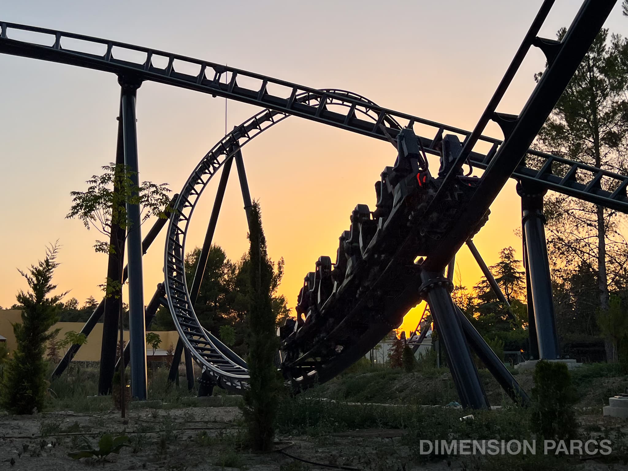 Train parcourant le coaster Batman Gotham City Escape à Parque Warner Madrid, au coucher du soleil