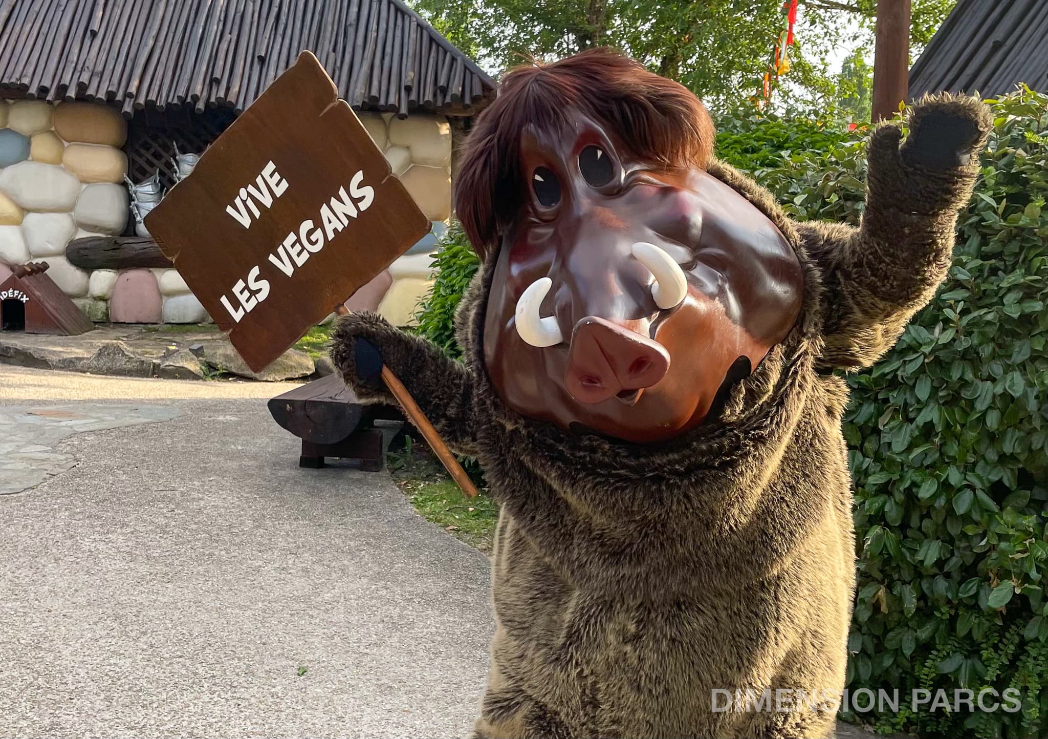 Personnage de sanglier du Parc Astérix brandissant une pancarte "vive les vegans"
