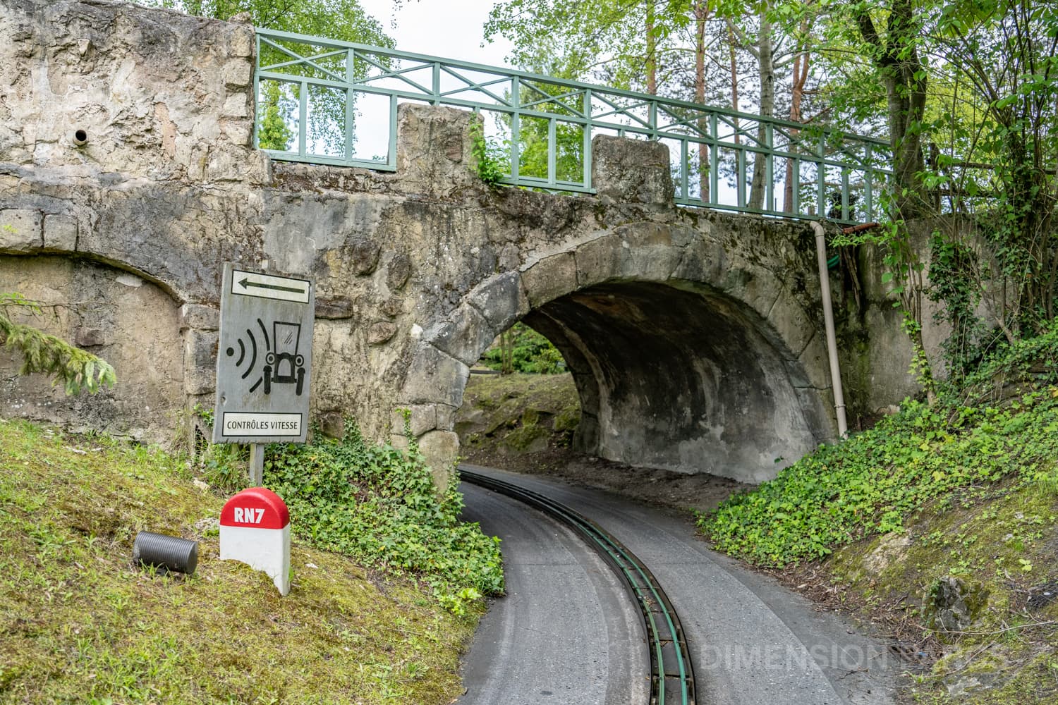 Route Nationale 7 passant sous un pont, avec un panneau avertissant d'un contrôle de vitesse