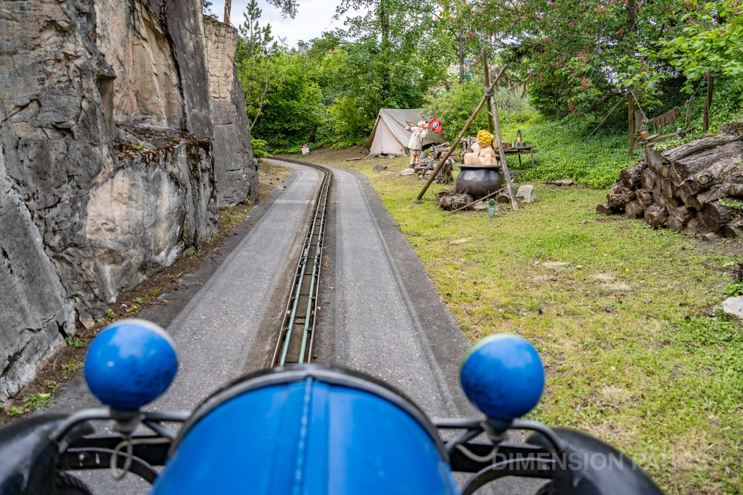 Voiture sur la route de la Nationale 7 au Parc Astérix, avec un campement scout au loin