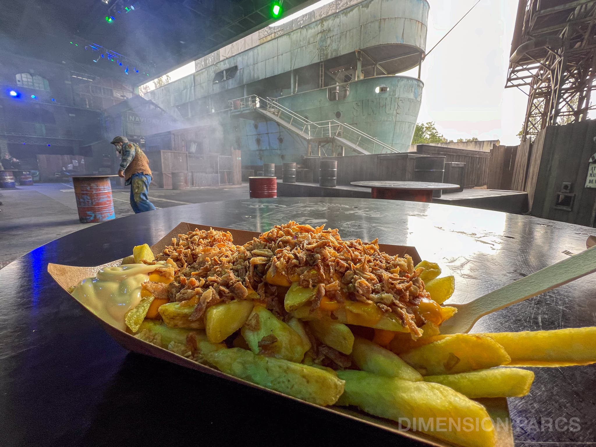 Barquette de frites surmontées d'une sauce cheddar et d'oignons frits